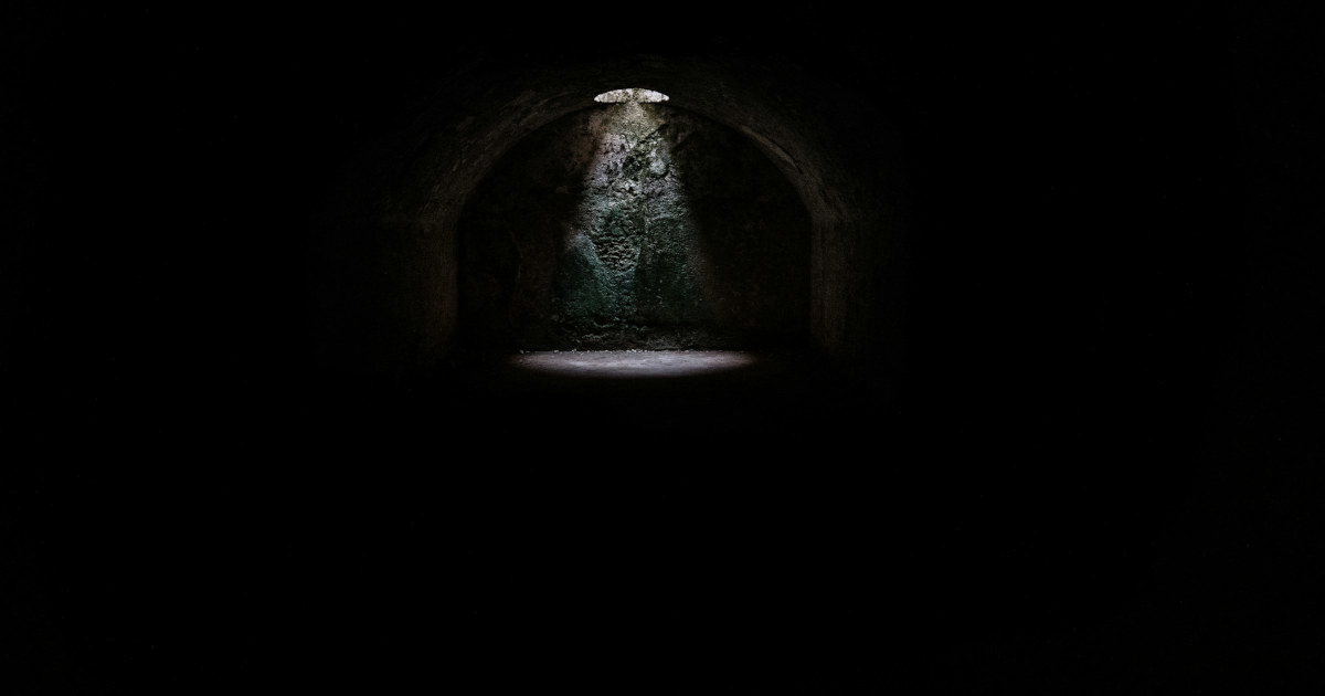 A spotlight coming from a hole in a dark underground cave in Minorca | Credit: @jeztimms | License: CC0