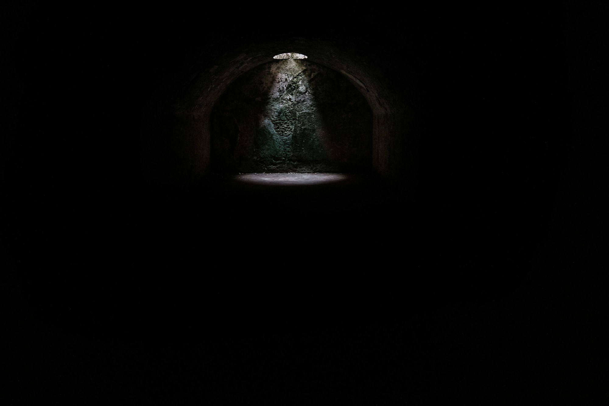 A spotlight coming from a hole in a dark underground cave in Minorca | Credit: @jeztimms | License: CC0